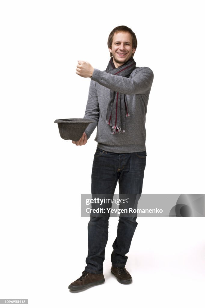 Magic, performance, circus, show concept - magician in top hat showing trick with imaginary rabbit