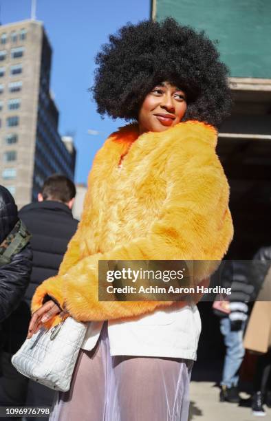 Oriane Adjibi is seen wearing an orange faux fur jacket by DOlls Kill, a Savage jumpsuit, white Public Desire shoes and a white Dior bag on the...