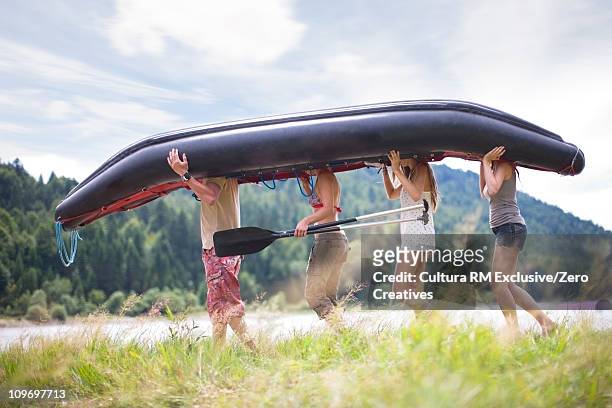 people carrying a canoe - girl rowing boat photos et images de collection