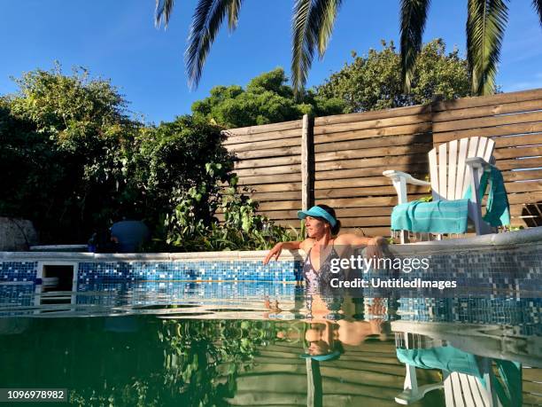 female in pool enjoying the summer sun at home - staycation stock pictures, royalty-free photos & images