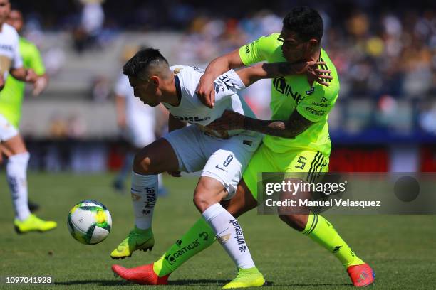 Felipe Mora of Pumas struggles for the ball against Anderson Santamaria of Atlas during the 3rd round match between Pumas UNAM and Atlas as part of...