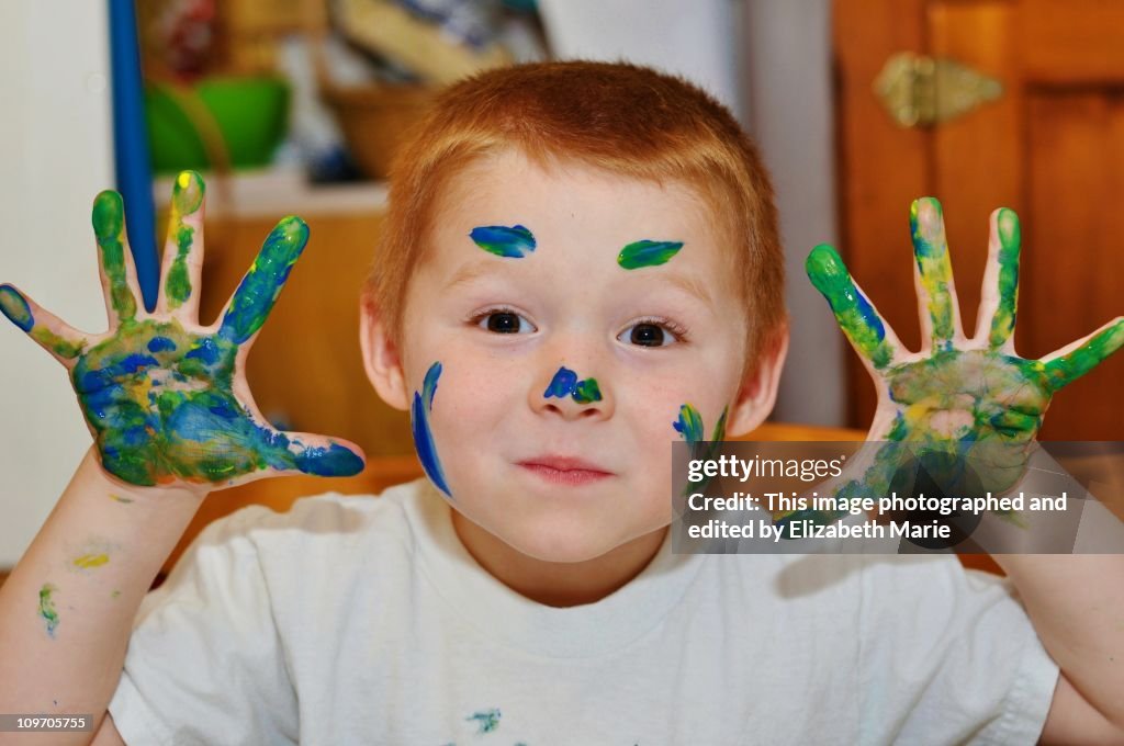 Boy playing with fingerpaint