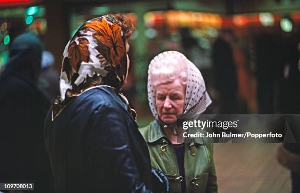 Two women wearing headscarves at a shopping centre in Manchester, England in 1976.