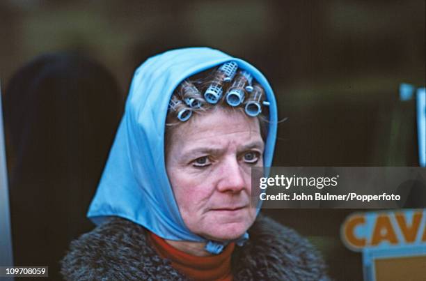 Woman wearing a headscarf over her curlers, Manchester, England in 1976.