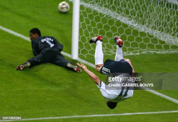 Germany's forward Miroslav Klose makes a flip after scoring the second goal as Saudi Arabia's goalie Mohammed Al Deayea at looks on at the Sapporo...