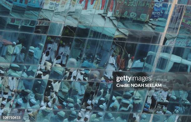 Seen through the window of a building, Indian Muslims offer Jummat-Ul-Vida prayers on the last Friday of Ramadan outside the historic Mecca Masjid in...