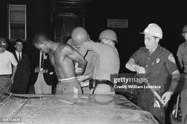 Members of the New York State Police and a member of the Rochester Police Department arrest a man during a race riot in Rochester, New York State,...