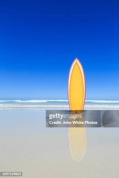 retro yellow surfboard on the beach. - surfer by the beach australia stock-fotos und bilder