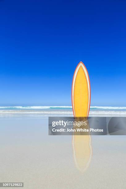 retro yellow surfboard on the beach. - surfer by the beach australia stock pictures, royalty-free photos & images