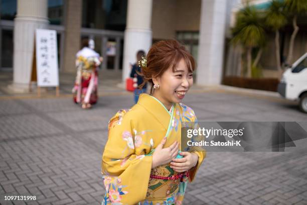 happy young woman in furisode kimono walking at coming-of-age ceremony - seijin no hi stock pictures, royalty-free photos & images