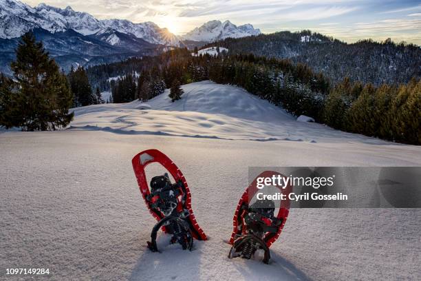 red snowshoes in front of wetterstein mountain range in winter - schneeschuh stock-fotos und bilder