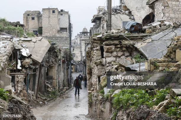 Syrian people walk amid destruction in the Bab al-Qinnasrin area in Aleppo's Old city, on February 10, 2019.