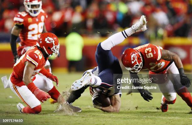 Rob Gronkowski of the New England Patriots is upended as he is tackled by Kendall Fuller and Anthony Hitchens of the Kansas City Chiefs in the first...