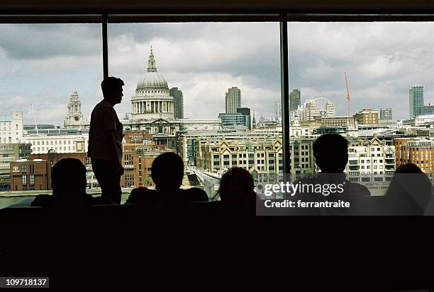 silhouette of people looking out window at london - millennium bridge stockfoto's en -beelden