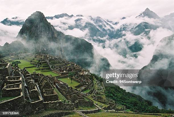 wolken umliegenden machu picchu und inka-ruinen - berg huayna picchu stock-fotos und bilder