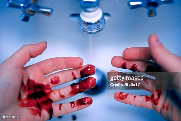 man washing blood off hands - murder/guilt concept - blood in sink stockfoto's en -beelden