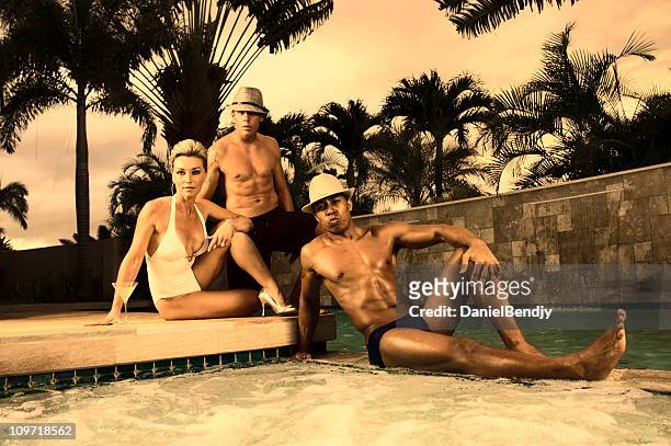 three young people relaxing near pool, toned - young men in speedos stock pictures, royalty-free photos & images
