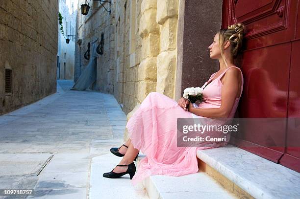 young woman wearing dress and waiting outside - malta wedding stock pictures, royalty-free photos & images