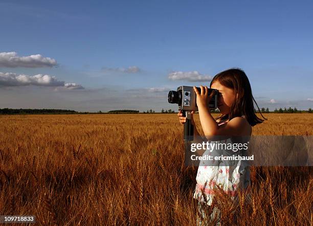 little girl standing in field and filming with vintage camera - girl camera bildbanksfoton och bilder