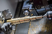 The CNC lathe machine cutting  the slot groove at the brass shaft .