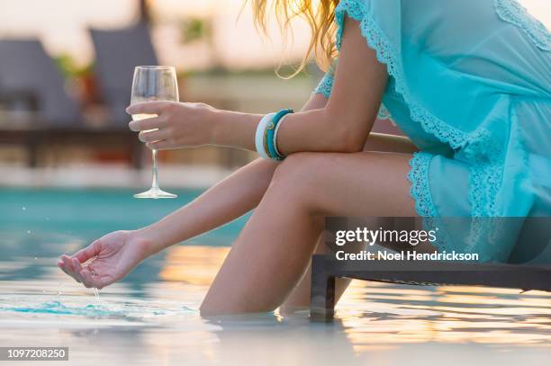 woman in blue dress with wine glass and feet in the pool - lido stock pictures, royalty-free photos & images
