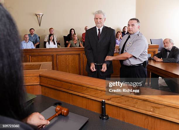 criminal defendant in court - handcuffed man standing in courtroom stock pictures, royalty-free photos & images