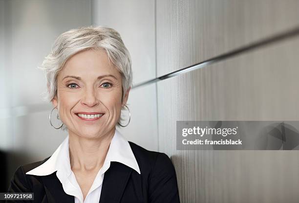 mature executive business woman smiling - president and ceo of smiles co masamichi toyama interview stockfoto's en -beelden