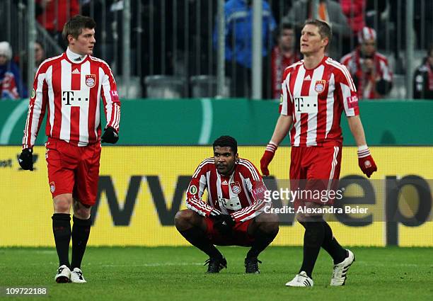 Toni Kroos, Breno and Bastian Schweinsteiger of Bayern Muenchen react after their team's loss of the DFB Cup semi final match between FC Bayern...