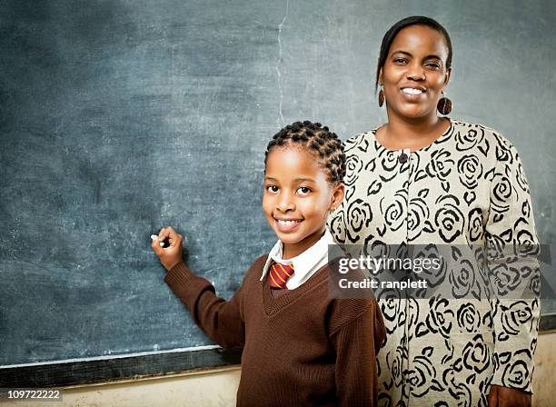 afrikanische im schulmädchen und lehrer an der tafel - teachers education uniform stock-fotos und bilder