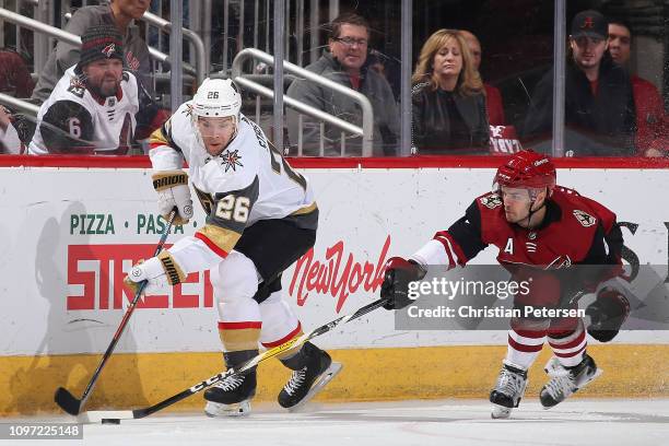 Paul Stastny of the Vegas Golden Knights and Niklas Hjalmarsson of the Arizona Coyotes skate for a loose puck during the NHL game at Gila River Arena...