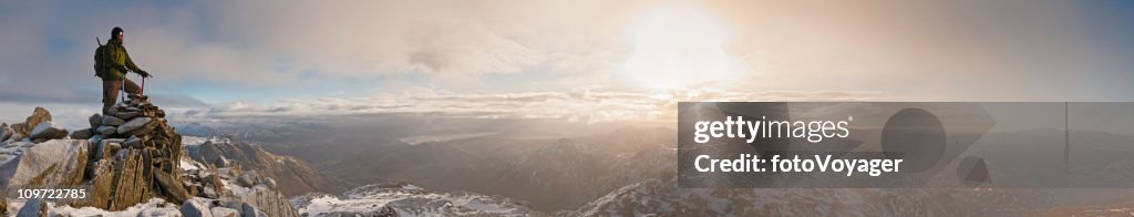 Mountaineer sunrise snow summit golden dawn panorama Lake District UK