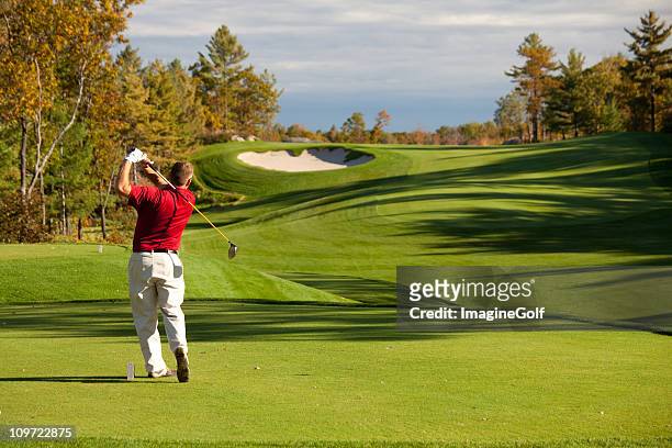 senior male caucasian golfer driving off the tee in fall - golf stock pictures, royalty-free photos & images