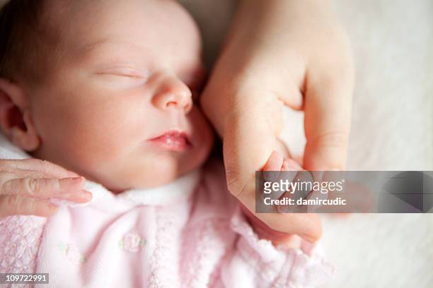 newborn baby holding mother's hand - mother sleeping baby bildbanksfoton och bilder