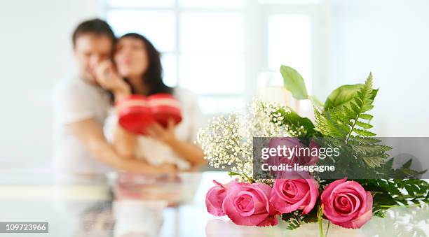 paar im hintergrund mit rosen auf einem tisch - couple chocolate stock-fotos und bilder