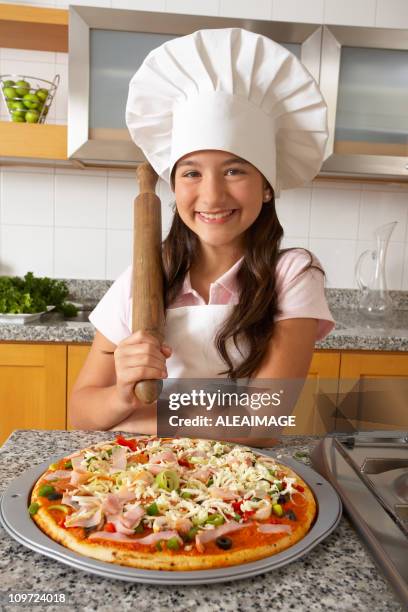 little girl wearing chefs hat holding rolling pin with pizza - pin up meisje stockfoto's en -beelden