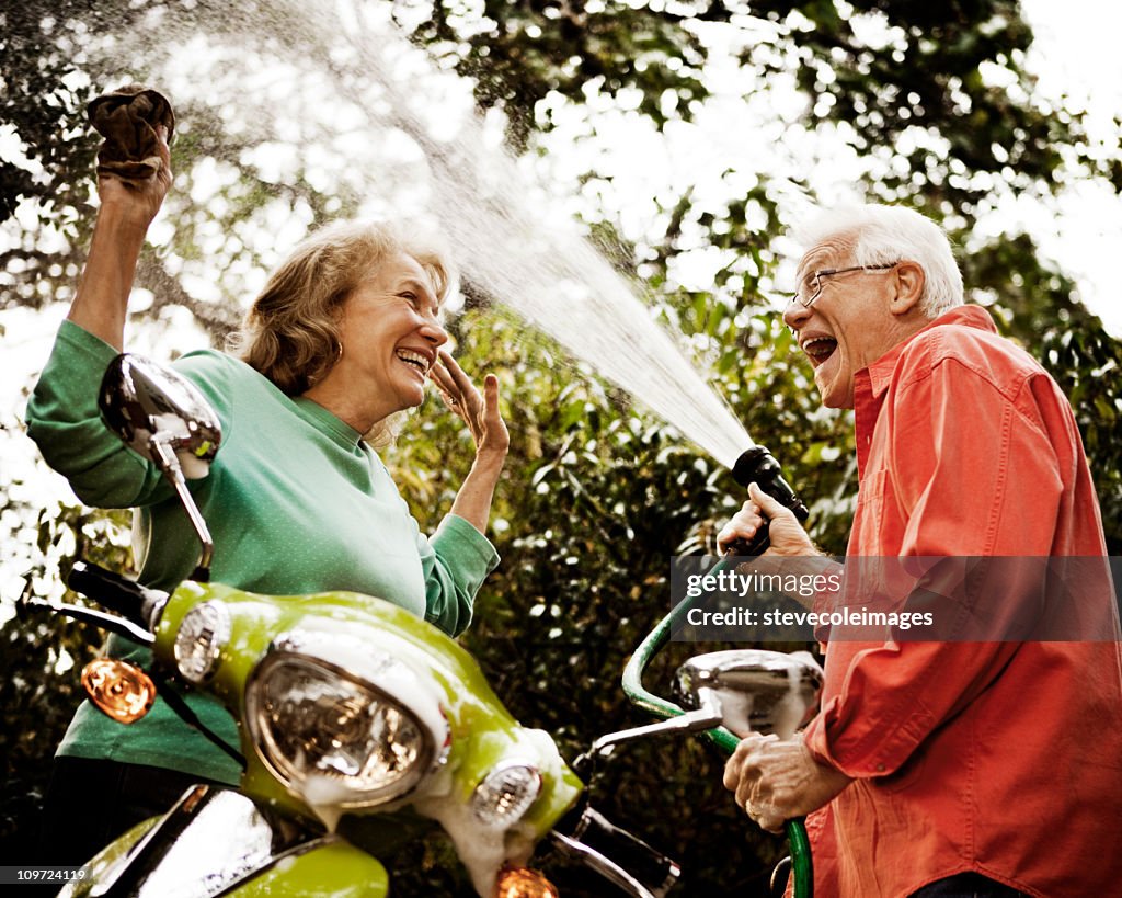 Senior Couple Washing Green Scooter