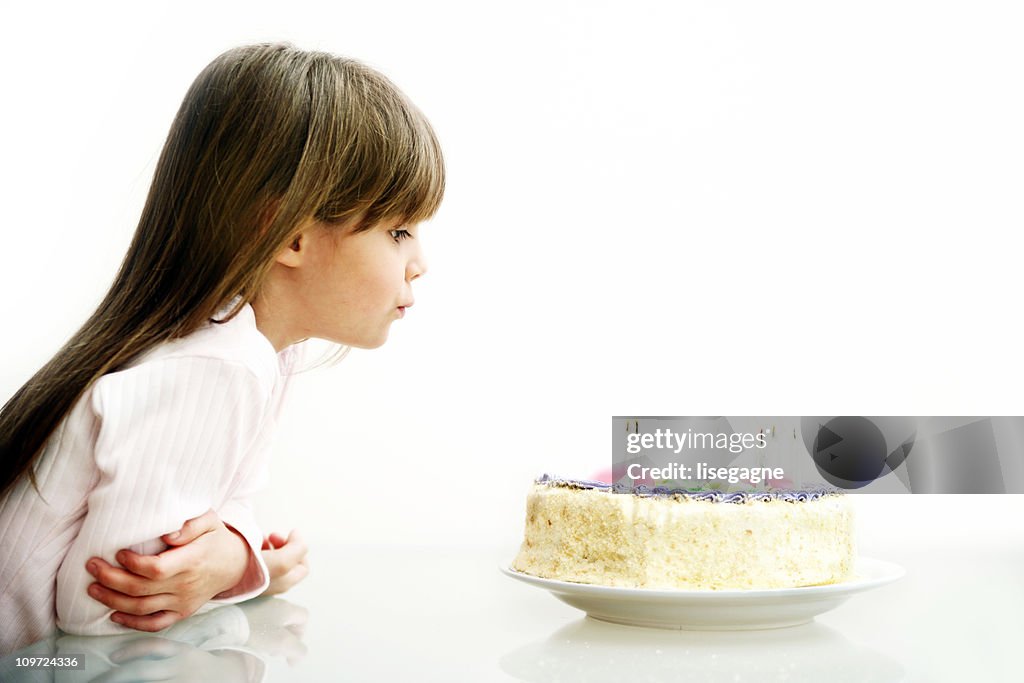 Menina soprando velas