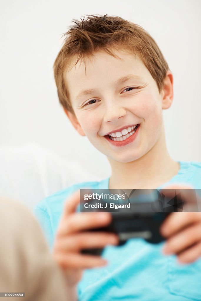 Menino sorridente segurando controlador de jogos
