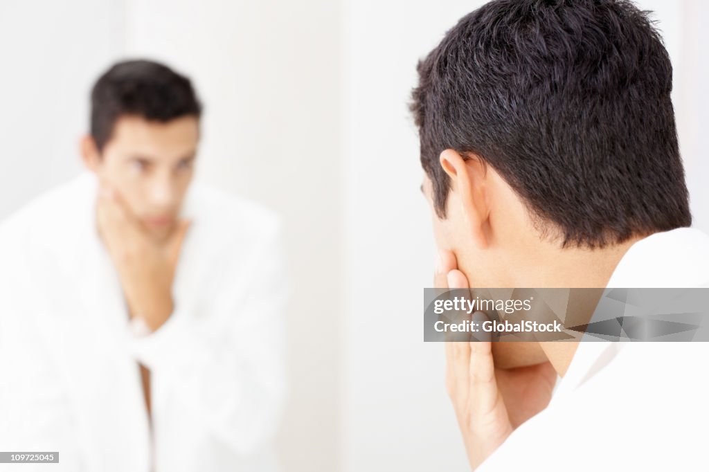 Aftershave - Young man looking at himself in mirror