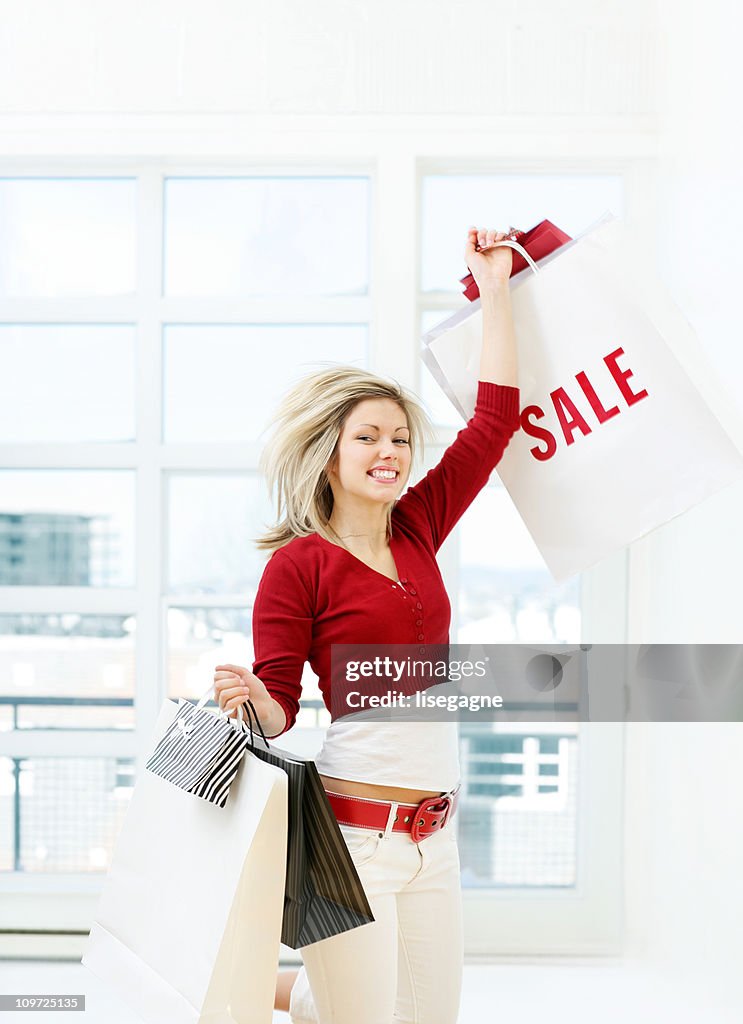 Young Woman Holding Shopping Bags Triumphantly