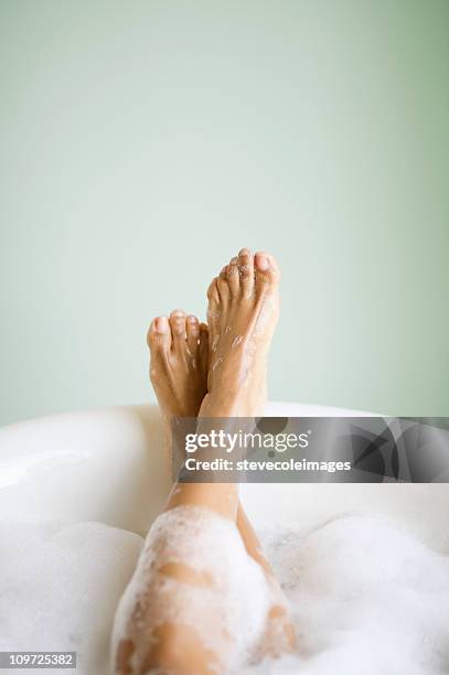 woman's legs and feet in bathtub with bubbles - foot spa stock pictures, royalty-free photos & images