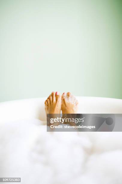 woman's feet emerging in bubble bath - bath stock pictures, royalty-free photos & images