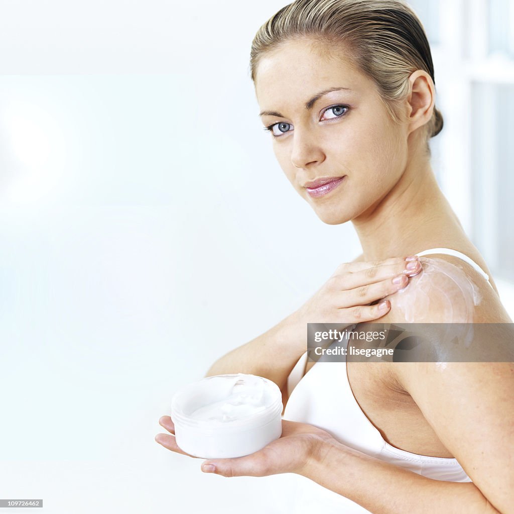 Woman applying moisturizer