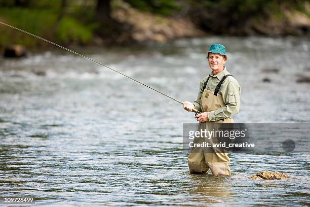 reifer mann fliegenfischen im mountain stream - waders stock-fotos und bilder