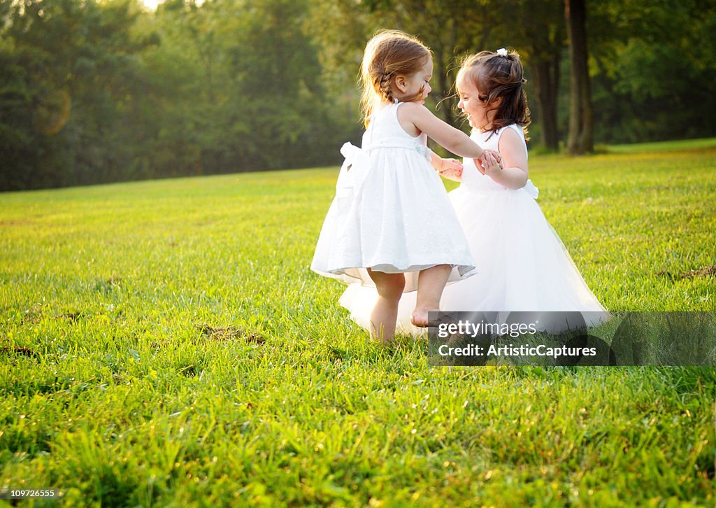 Dois pequenos Princesses dançar na relva