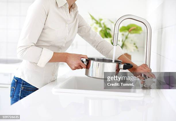 a mulher está no lavatório com uma panela com cabo. - wash bowl imagens e fotografias de stock