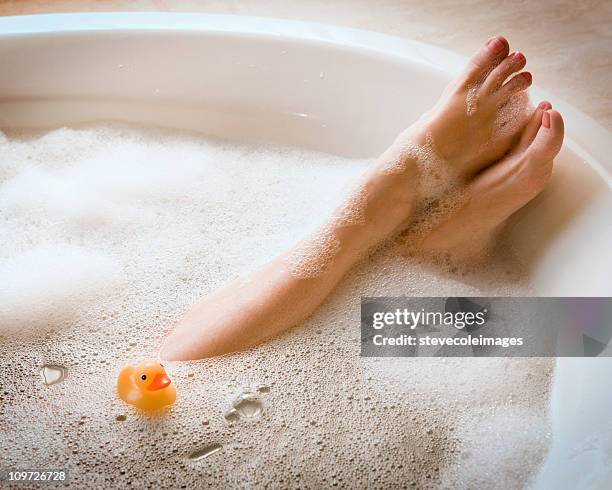 woman's legs in bubble bath with ducky - foot spa stock pictures, royalty-free photos & images