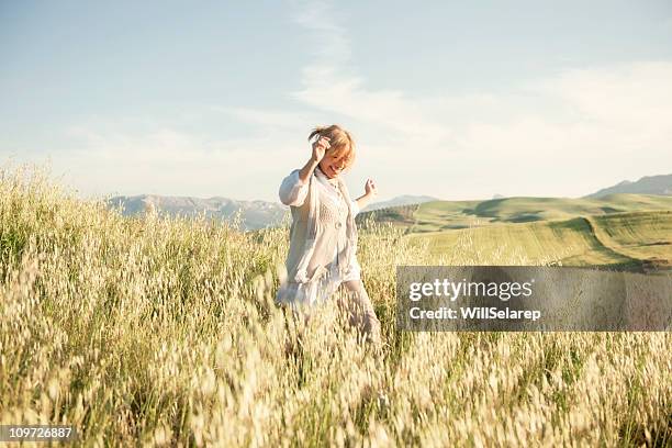 femme courir dans un champ herbeux - joyeux photos et images de collection