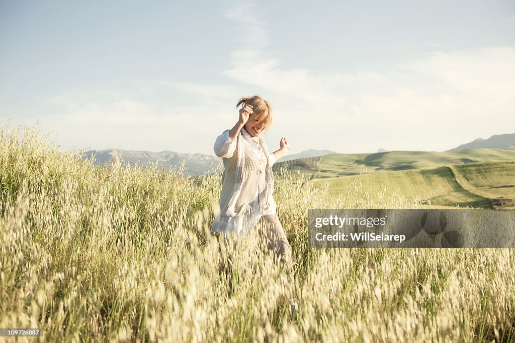 Woman running in grassy field