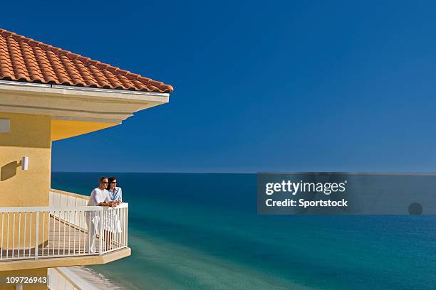 par de pie en el balcón con vista al mar - beach house balcony fotografías e imágenes de stock